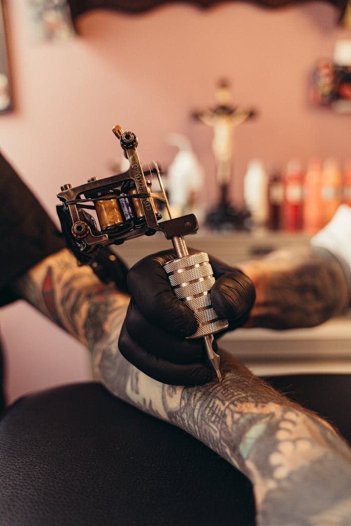 service-04 Intense close-up of a tattoo artist working on a clients arm in a tattoo studio.