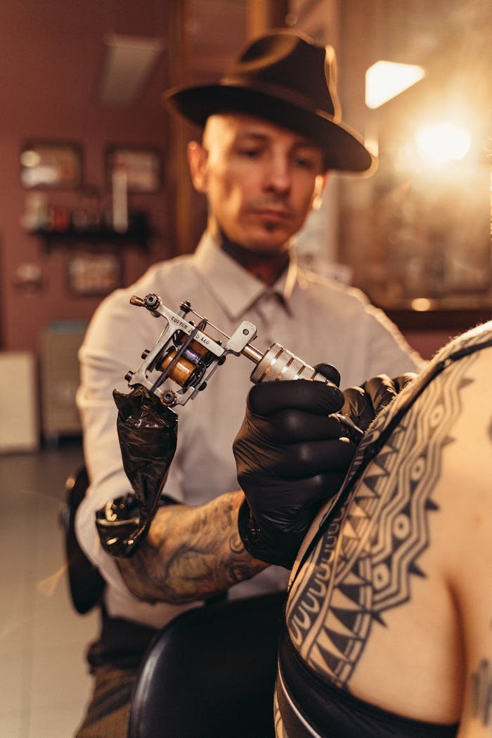 A professional tattoo artist creating intricate designs in a studio.